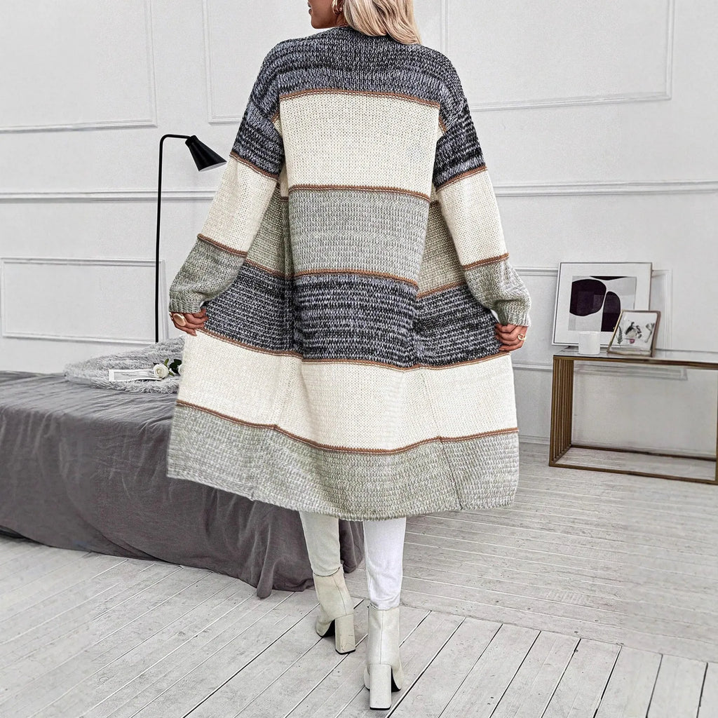 Grey women's knitted long cardigan with loose fit and long sleeves on a hanger.