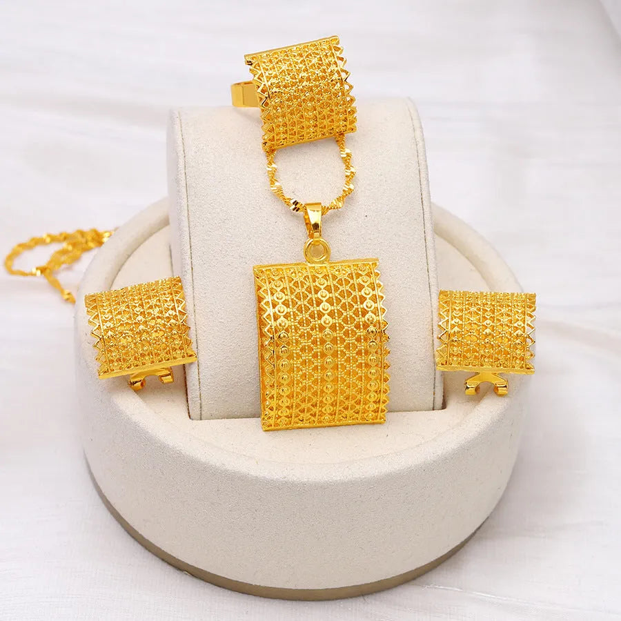 Golden copper bridal jewellery set featuring a necklace, pair of earrings, and a ring on a display.