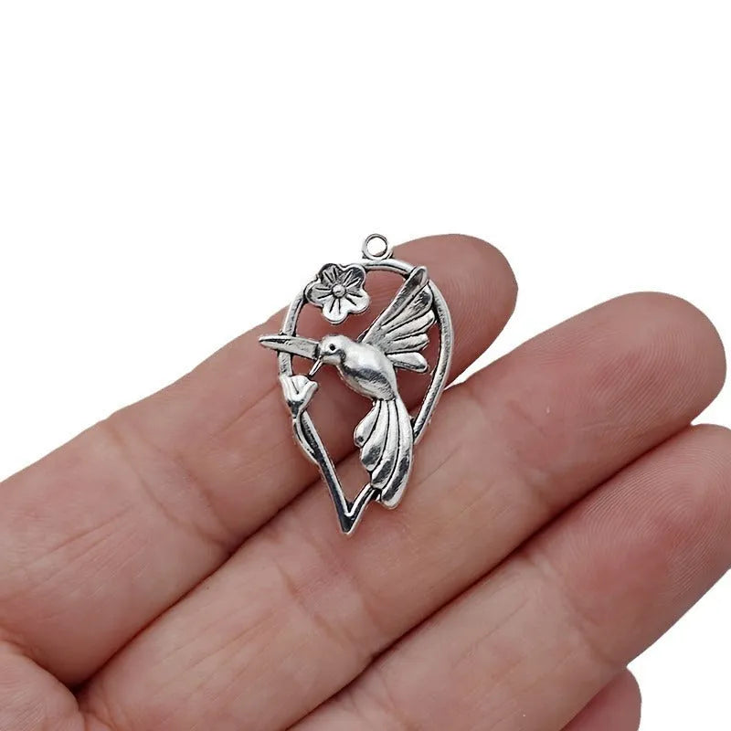 Close-up of an alloy magpie bird pendant charm with electroplated finish for DIY jewellery.