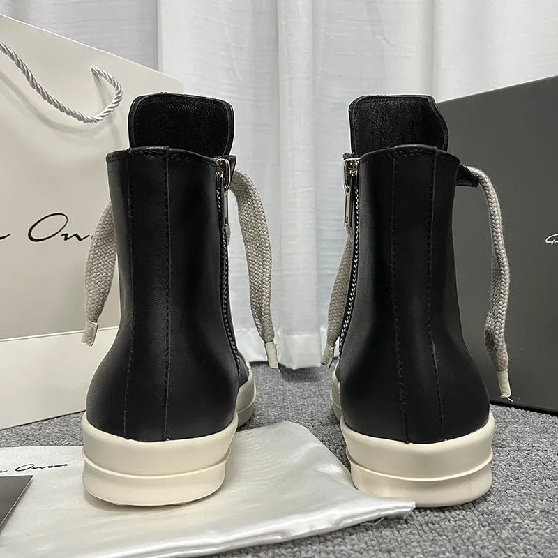 Black high-top leather sneakers with a side zipper and visible stitching on a white background.