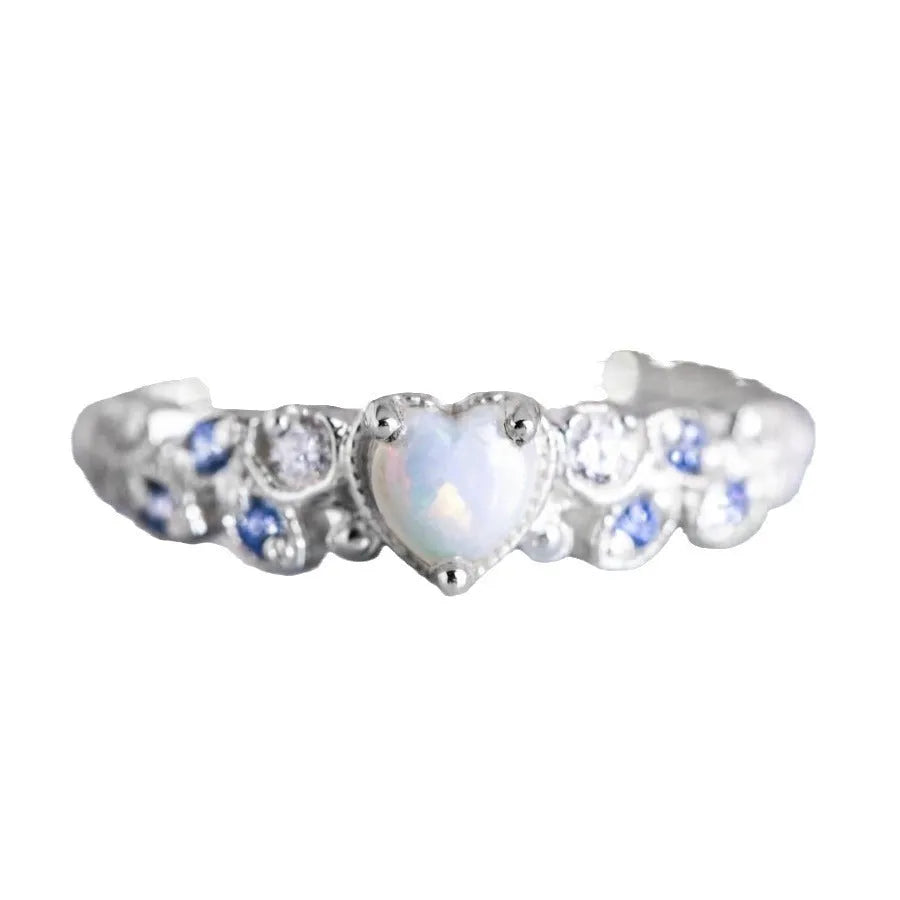 White alloy women's heart ring with floral and ocean pattern design on a hand.