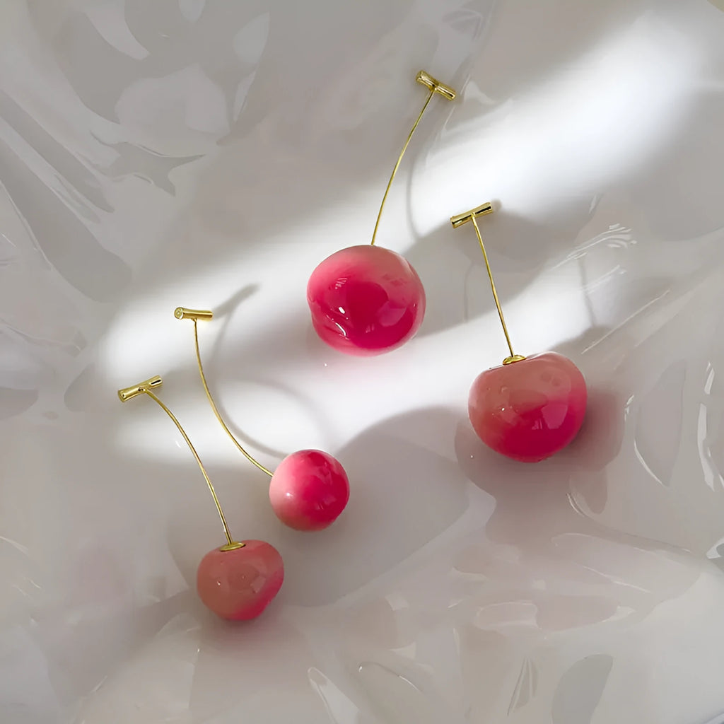 A pair of peach-shaped acrylic earrings on copper posts, shown in small and large size variants.