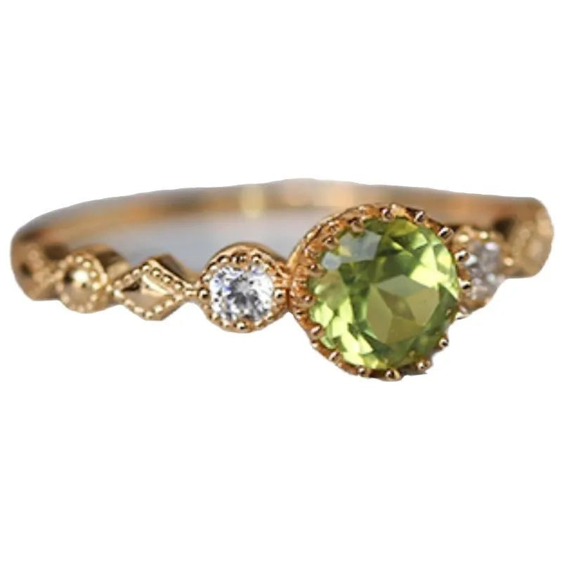 Japanese style geometric copper ring with green imitation peridot stone on a hand.