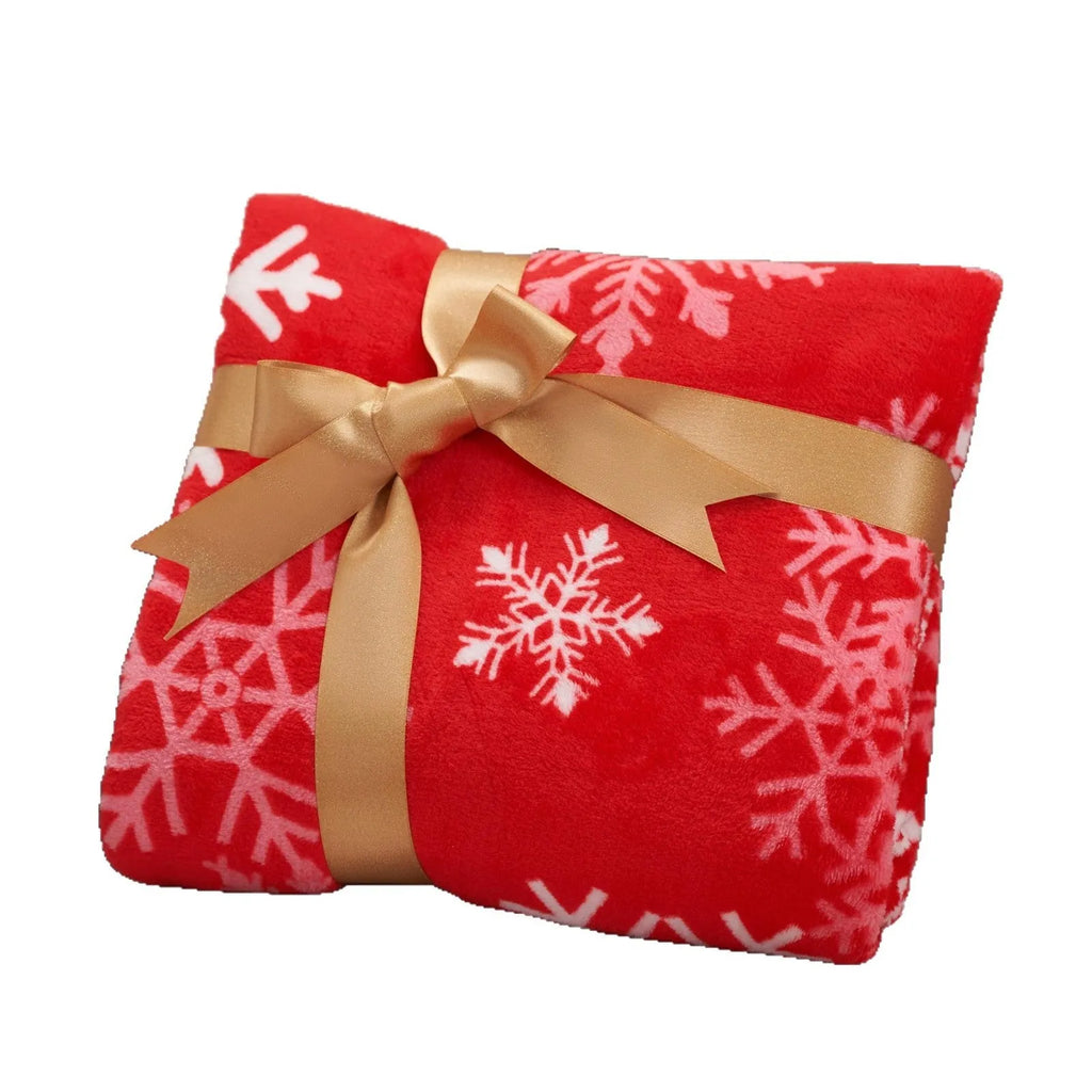 Soft red polyester flannel Christmas blanket folded on a bed