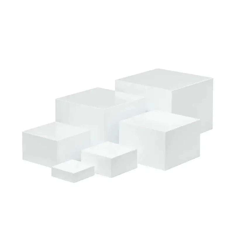 White and transparent plastic cube dessert display stands arranged in a tiered set.