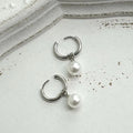 A pair of women's pearl-coloured alloy geometry drop earrings with a hip hop style.