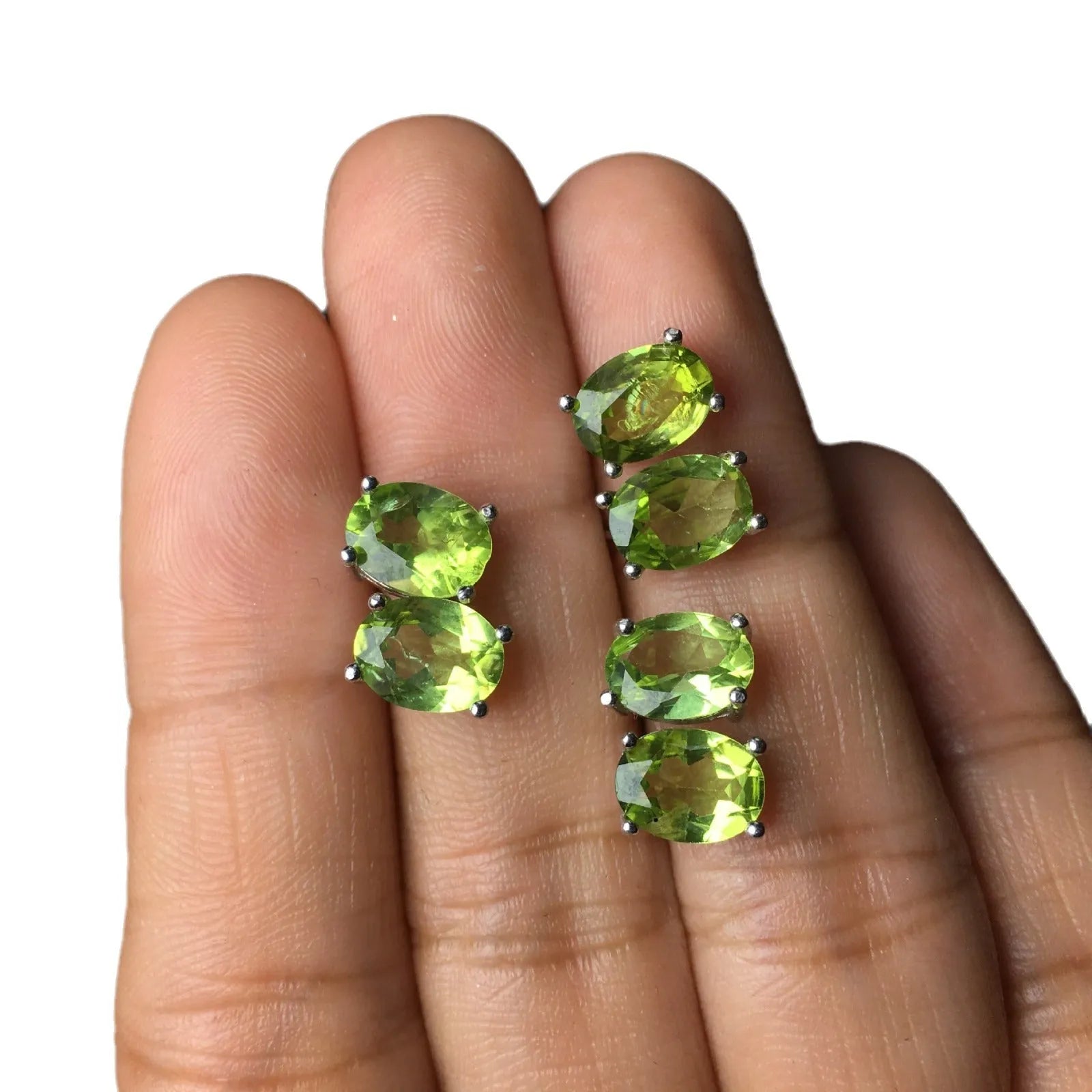 Grass green natural olivine oval stud earrings in sterling silver on a white background.