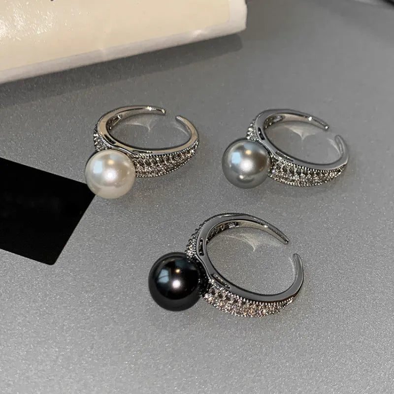 Open finger ring with geometric design, black pearl accent, and adjustable copper band