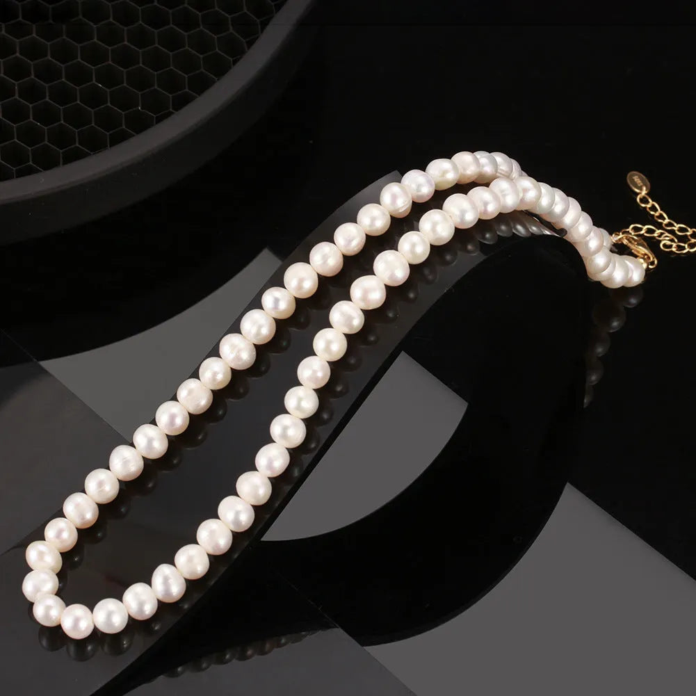 Adjustable silver necklace with a string of freshwater pearls on a model