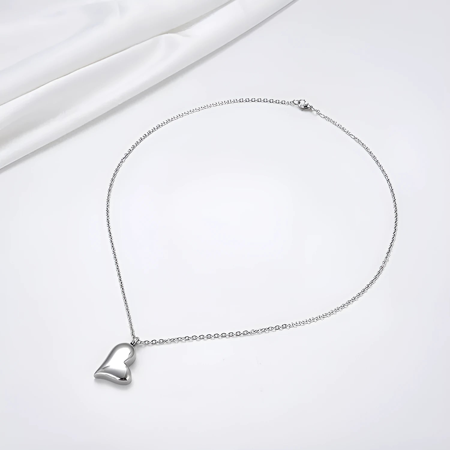 Silver stainless steel necklace with curved peach heart pendant on adjustable chain