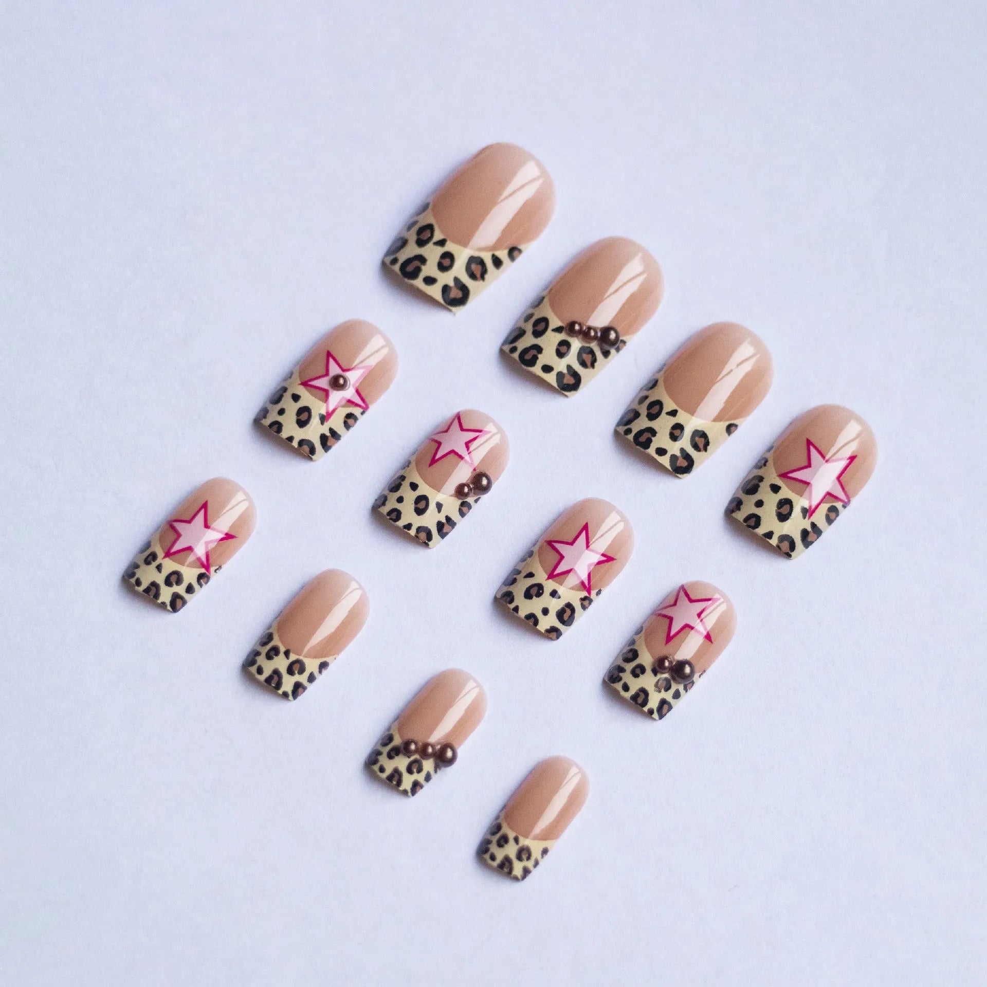 French leopard print nail art with five-pointed stars, pearl and diamond accents on wearable nail pieces