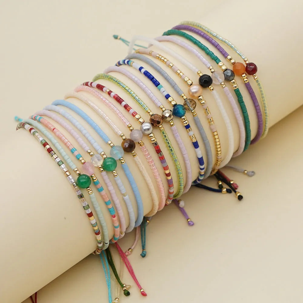 Close-up of a colourful Bohemian-style beaded bracelet featuring semi-precious stone and glass beads on a wrist.