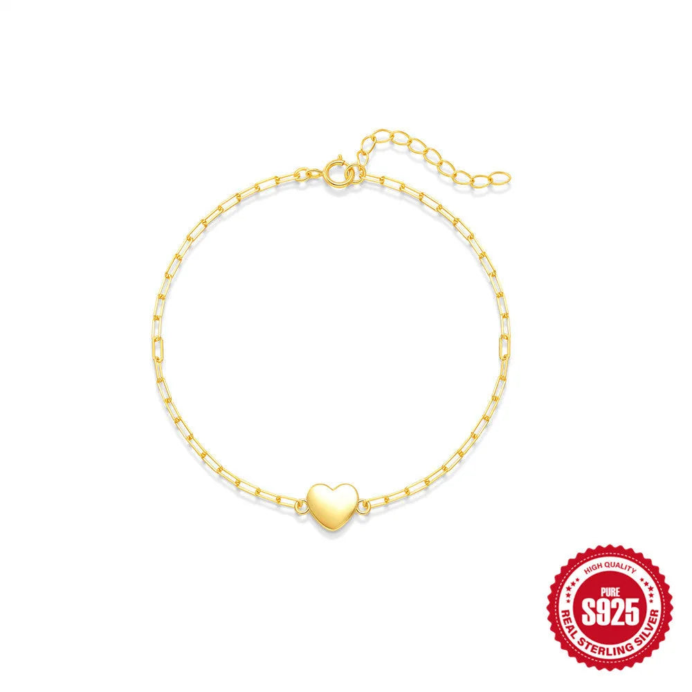 Gold tone S925 sterling silver bracelet with glossy heart charm and clip chain fastening