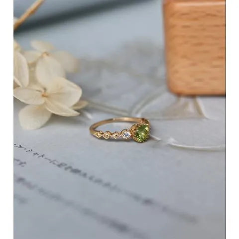 Japanese style geometric copper ring with green imitation peridot stone on a hand.