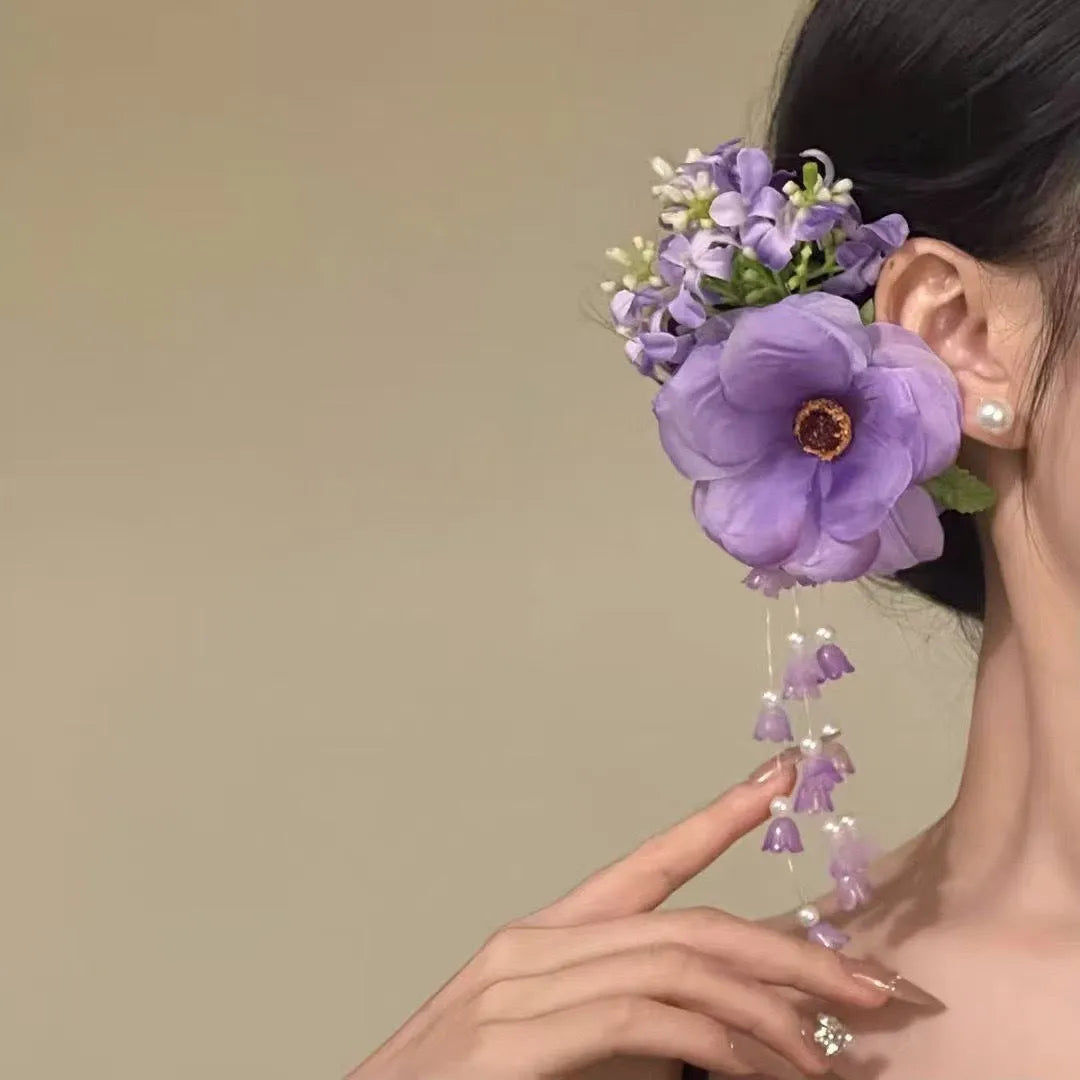 Close-up of a handcrafted women's hair clip with a flower tassel in purple and yellow colour options.
