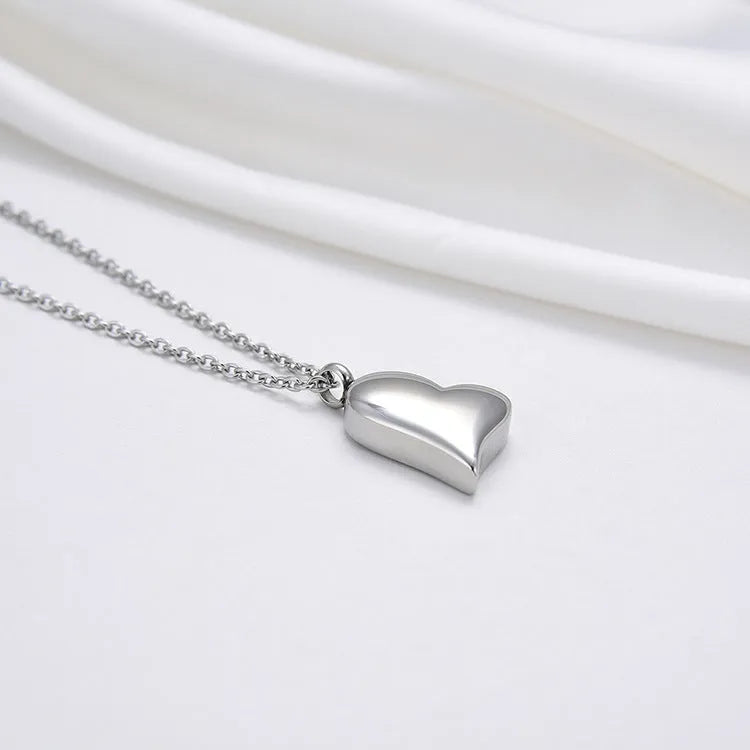 Silver stainless steel necklace with curved peach heart pendant on adjustable chain