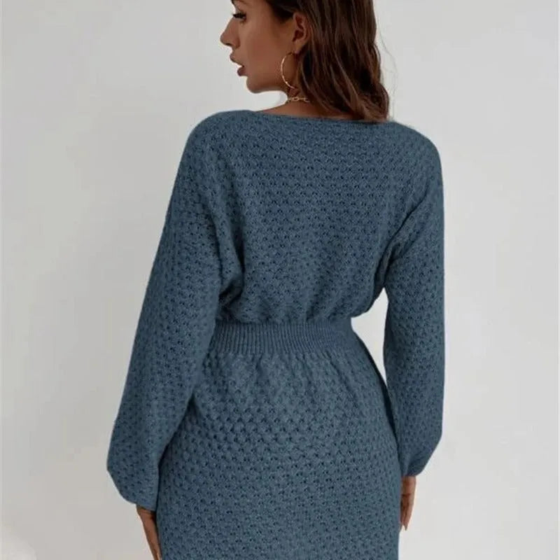 Blue women's knitted dress with white hand-crocheted flower details on the chest, showing a fitted waist and round neck.