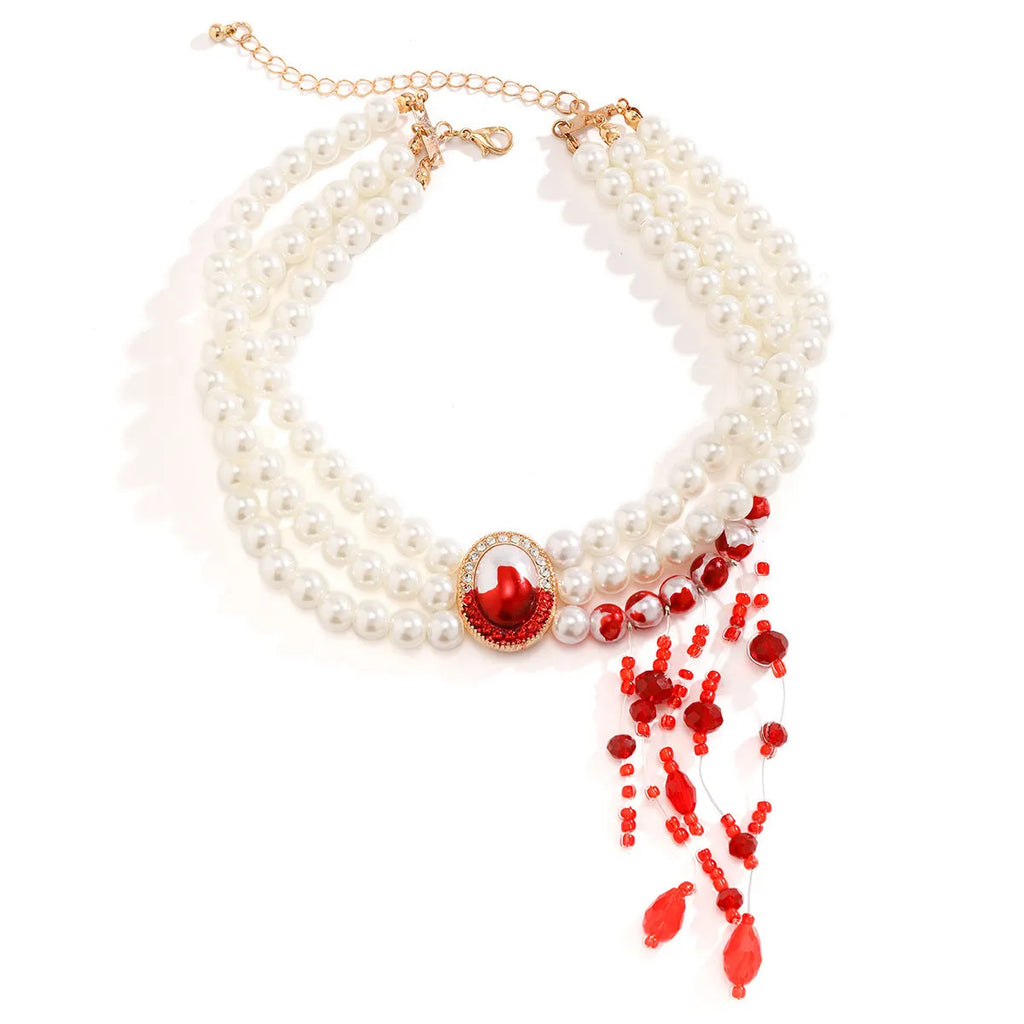 Gold gothic pearl collar necklace jewellery set with matching earrings and bracelet on a dark background.