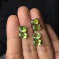 Grass green natural olivine oval stud earrings in sterling silver on a white background.