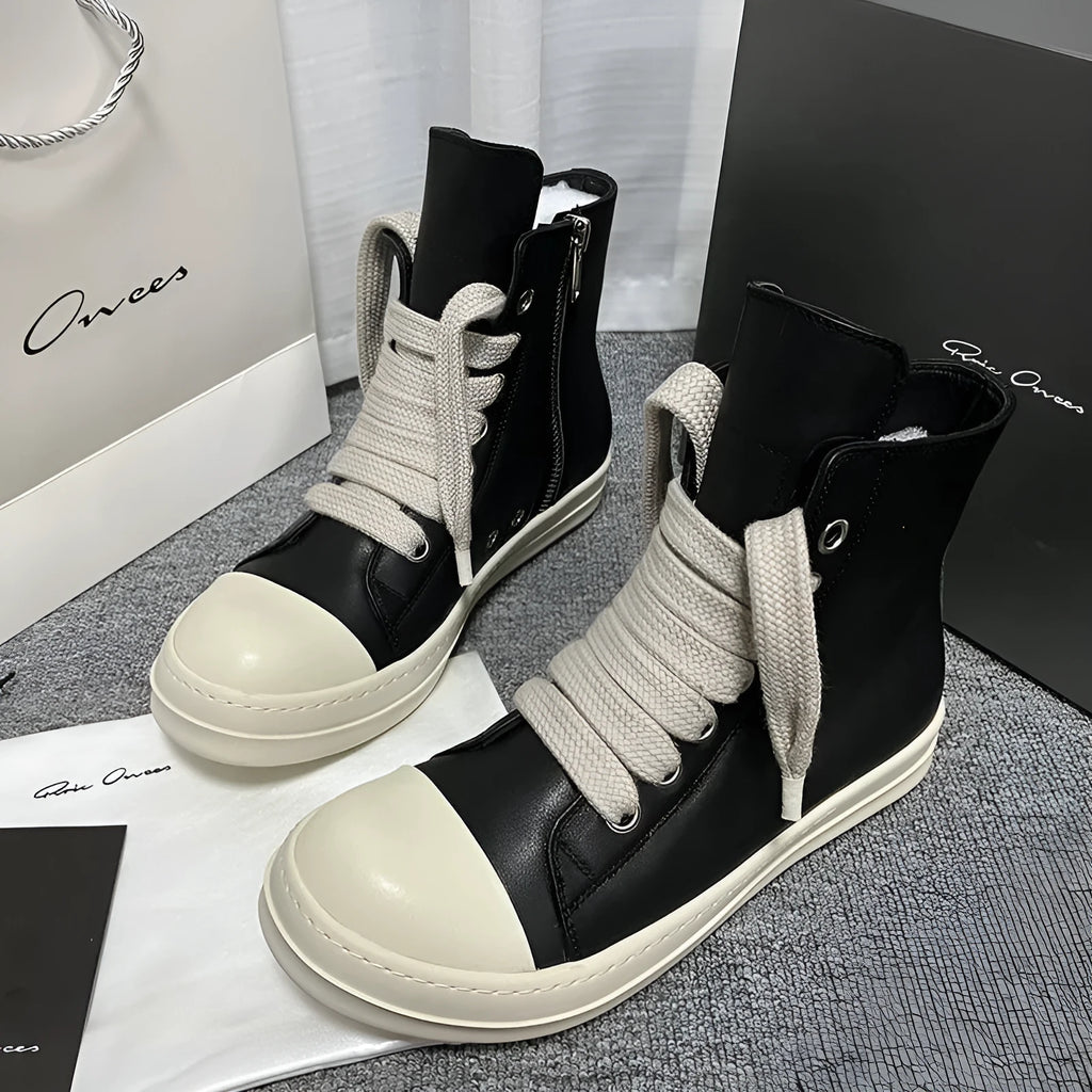 Black high-top leather sneakers with a side zipper and visible stitching on a white background.