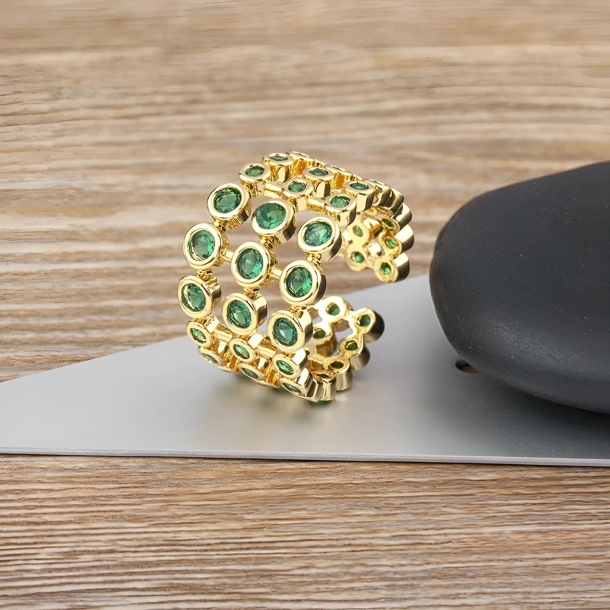 Three-layer wide band statement ring with green zircon stones and gold plating on copper base