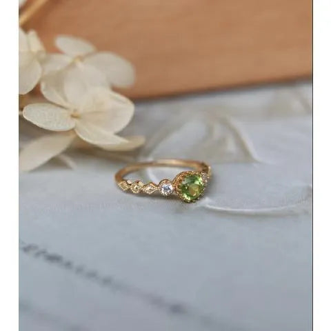 Japanese style geometric copper ring with green imitation peridot stone on a hand.