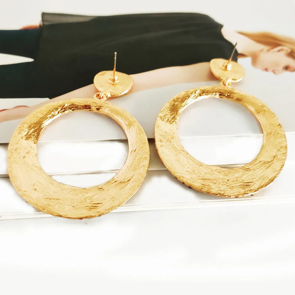A pair of large round cartoon-style pendant earrings with coloured rhinestones on alloy metal.