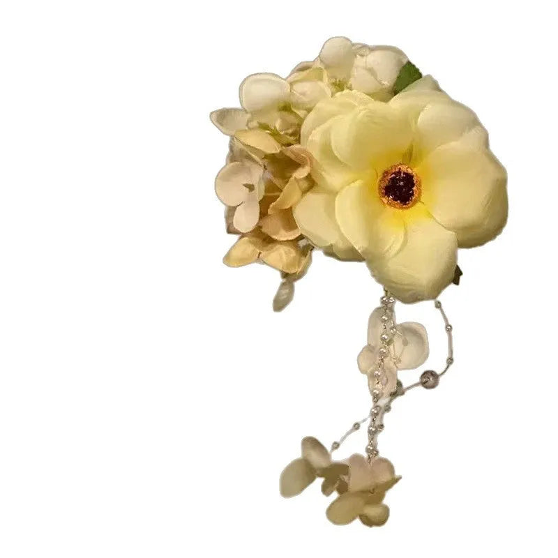 Close-up of a handcrafted women's hair clip with a flower tassel in purple and yellow colour options.