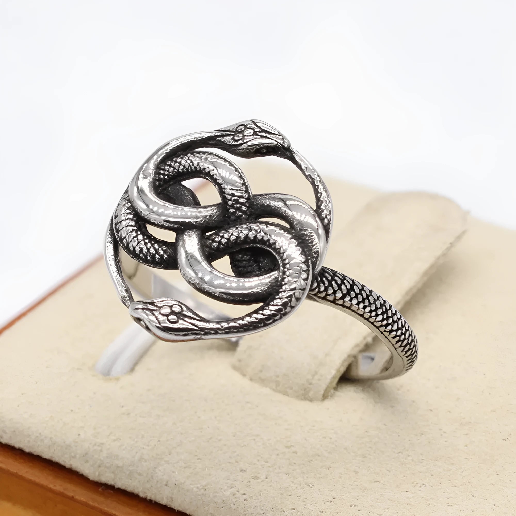 Titanium steel double snake ring in steel colour on a plain background, showing retro design detail.