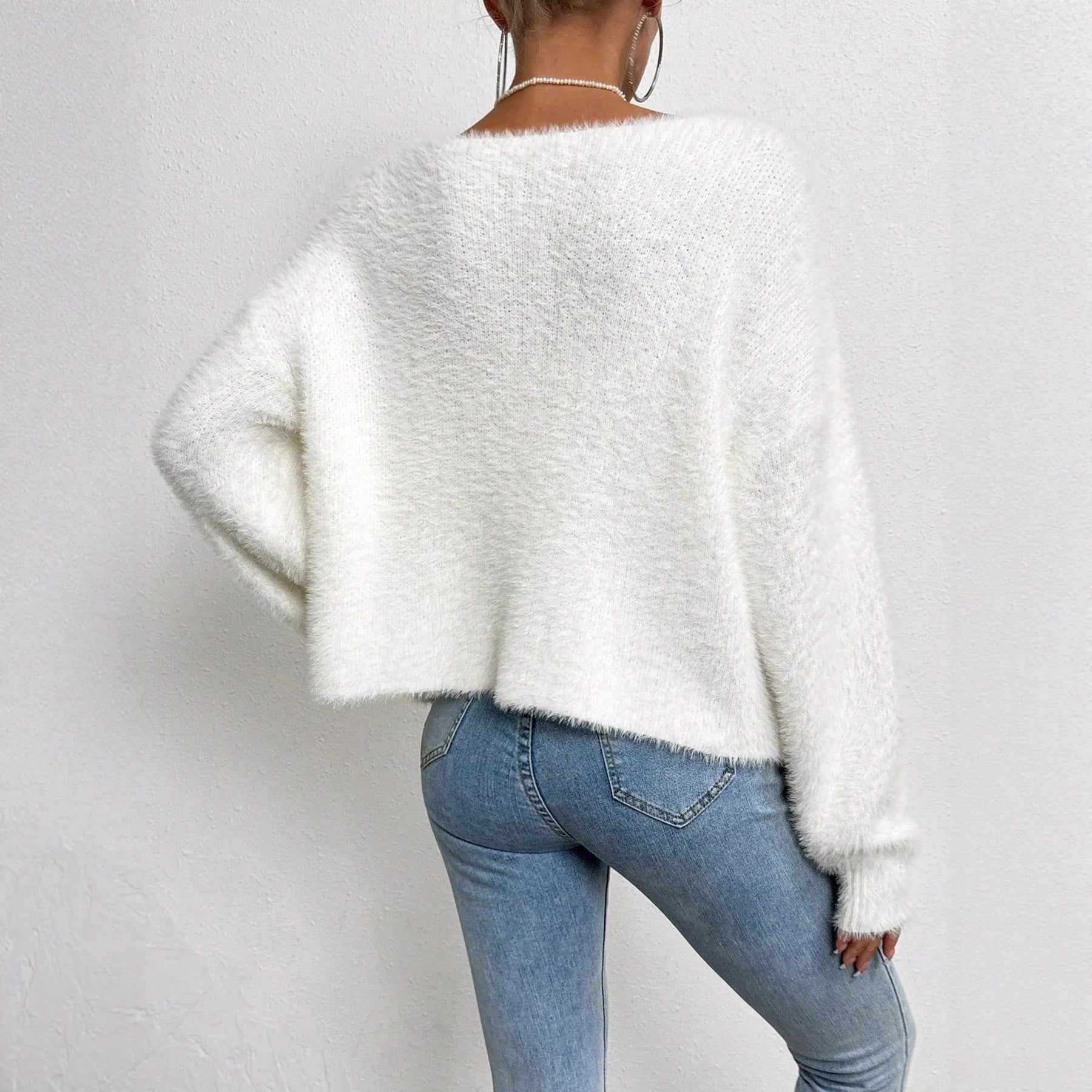 White women's V-neck cardigan sweater with bead-knit texture on a hanger.