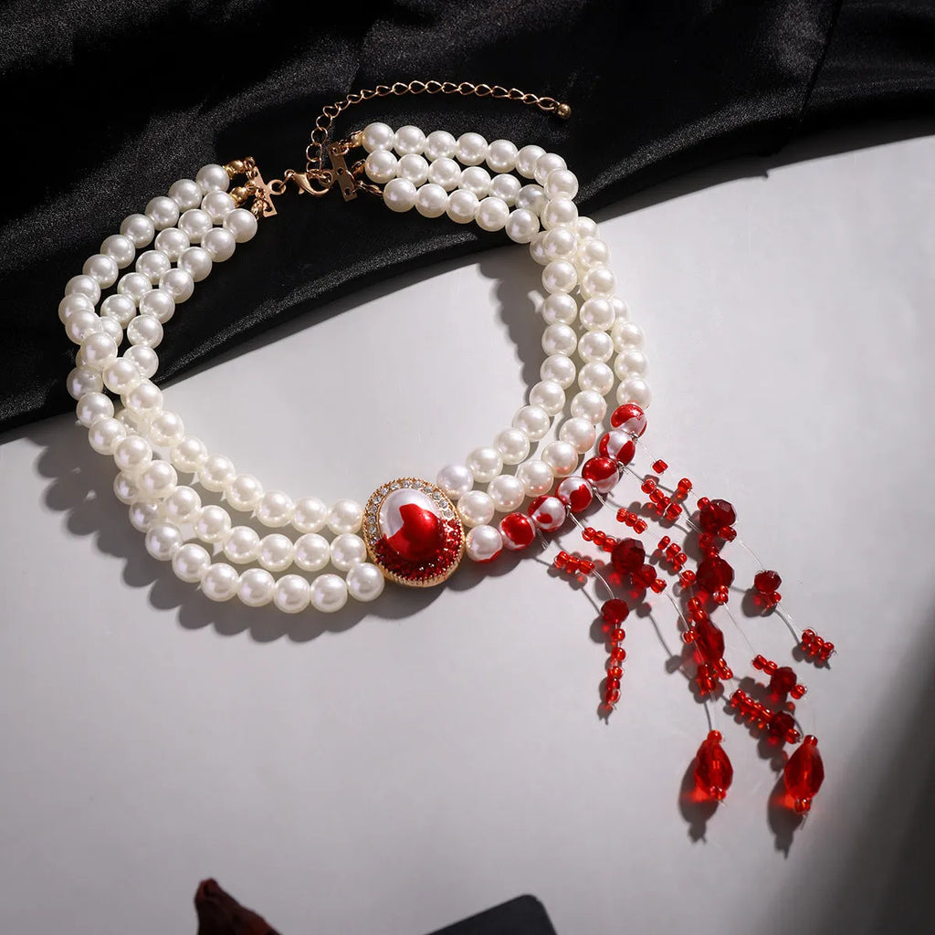 Gold gothic pearl collar necklace jewellery set with matching earrings and bracelet on a dark background.
