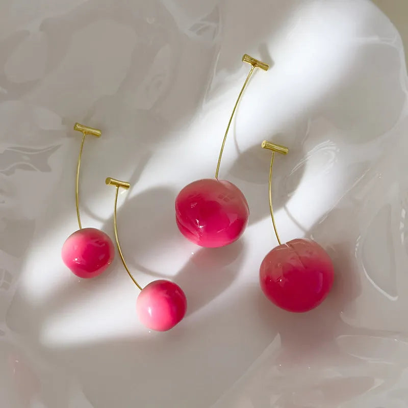 A pair of peach-shaped acrylic earrings on copper posts, shown in small and large size variants.