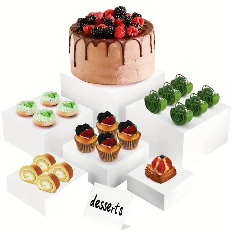 White and transparent plastic cube dessert display stands arranged in a tiered set.