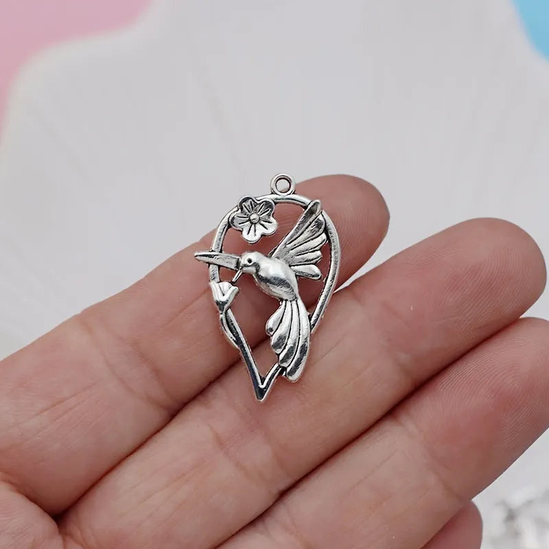 Close-up of an alloy magpie bird pendant charm with electroplated finish for DIY jewellery.