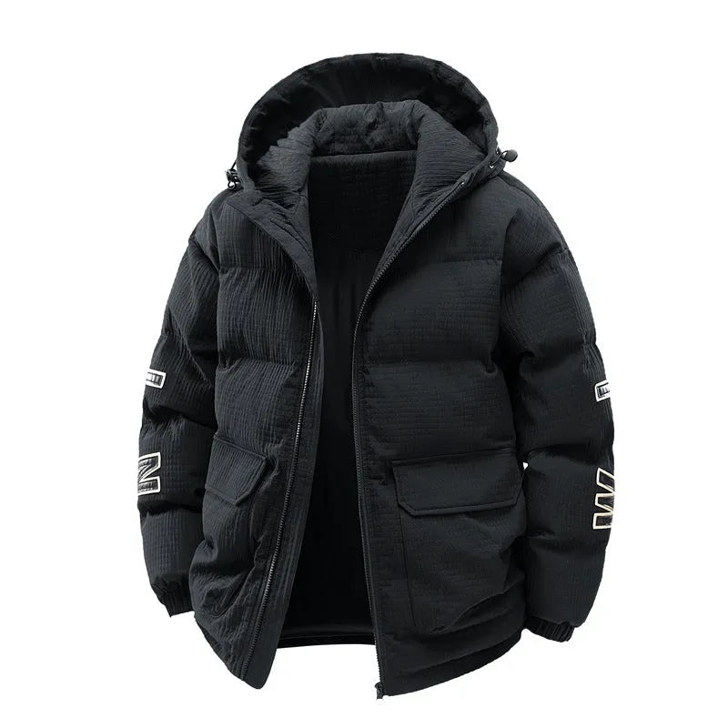 A man wearing a black hooded cotton-padded winter coat with letter-print detail and side pockets.