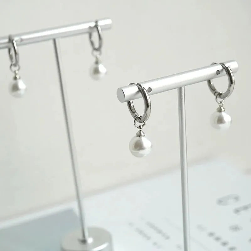 A pair of women's pearl-coloured alloy geometry drop earrings with a hip hop style.