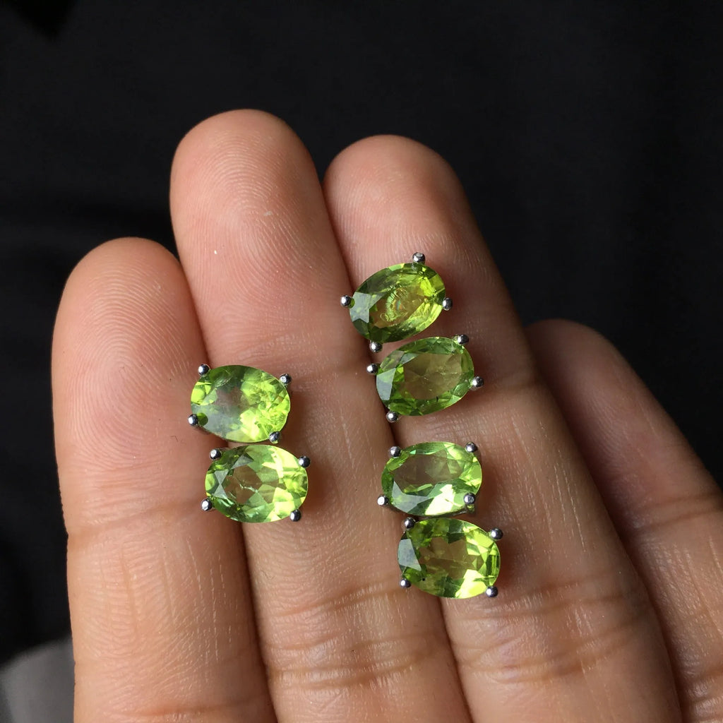 Grass green natural olivine oval stud earrings in sterling silver on a white background.