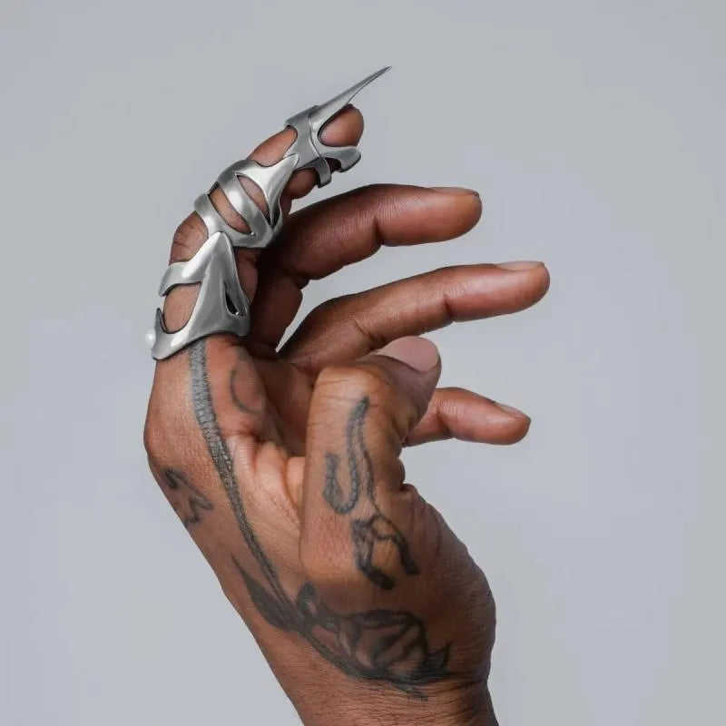 Silver alloy punk armour finger stall fashion ring on a finger.