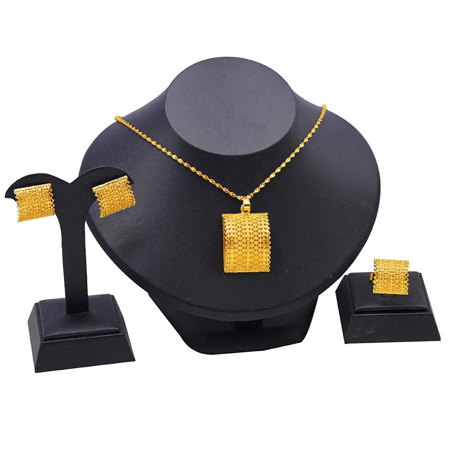 Golden copper bridal jewellery set featuring a necklace, pair of earrings, and a ring on a display.