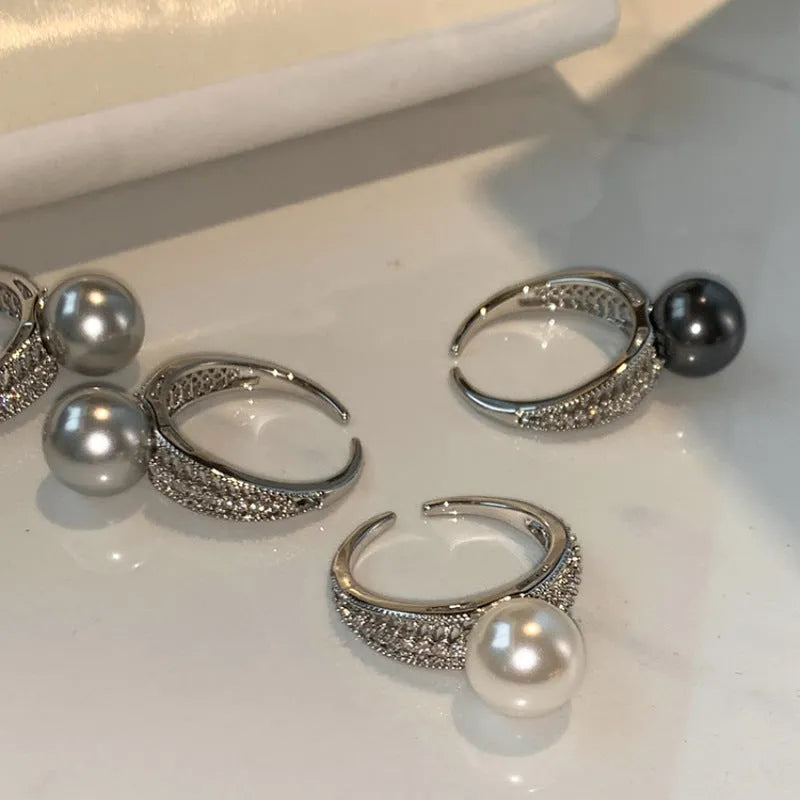 Open finger ring with geometric design, black pearl accent, and adjustable copper band