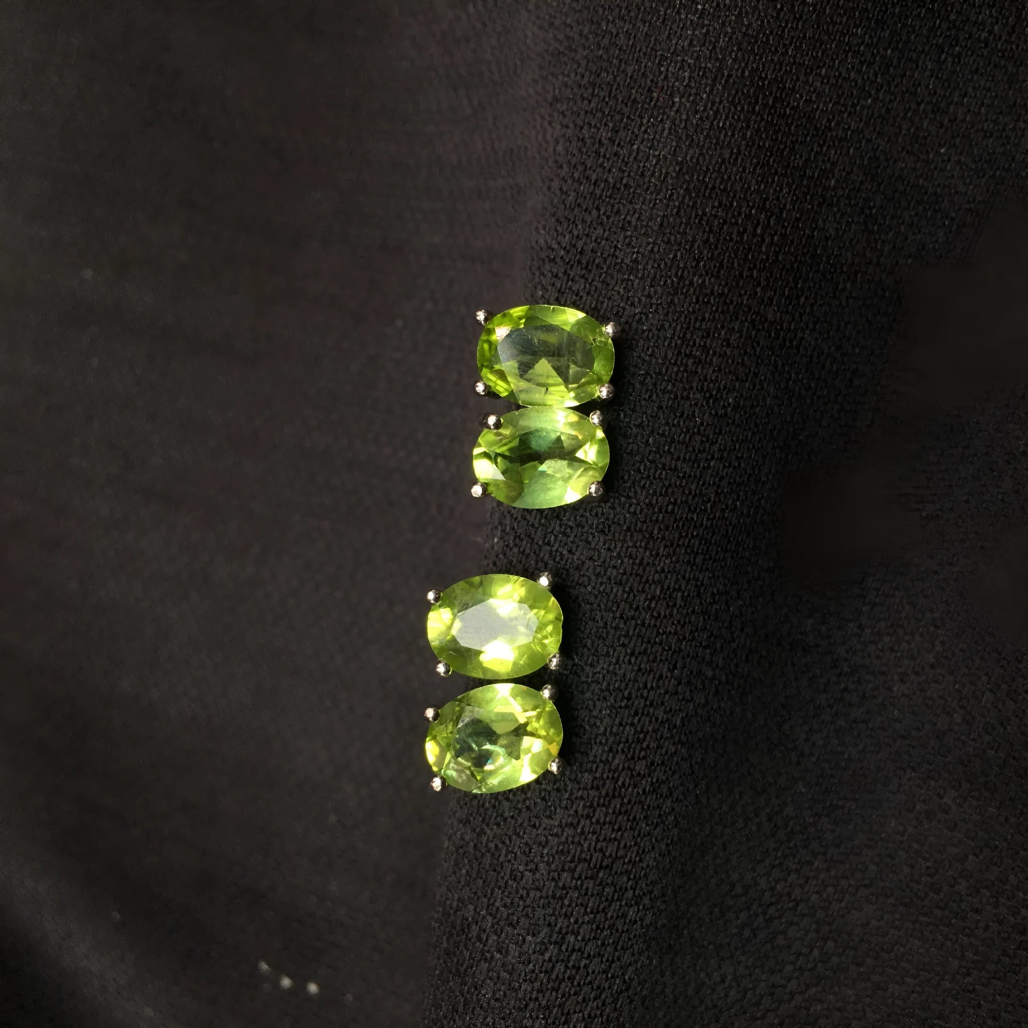 Grass green natural olivine oval stud earrings in sterling silver on a white background.