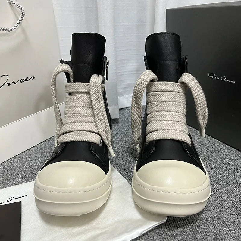 Black high-top leather sneakers with a side zipper and visible stitching on a white background.