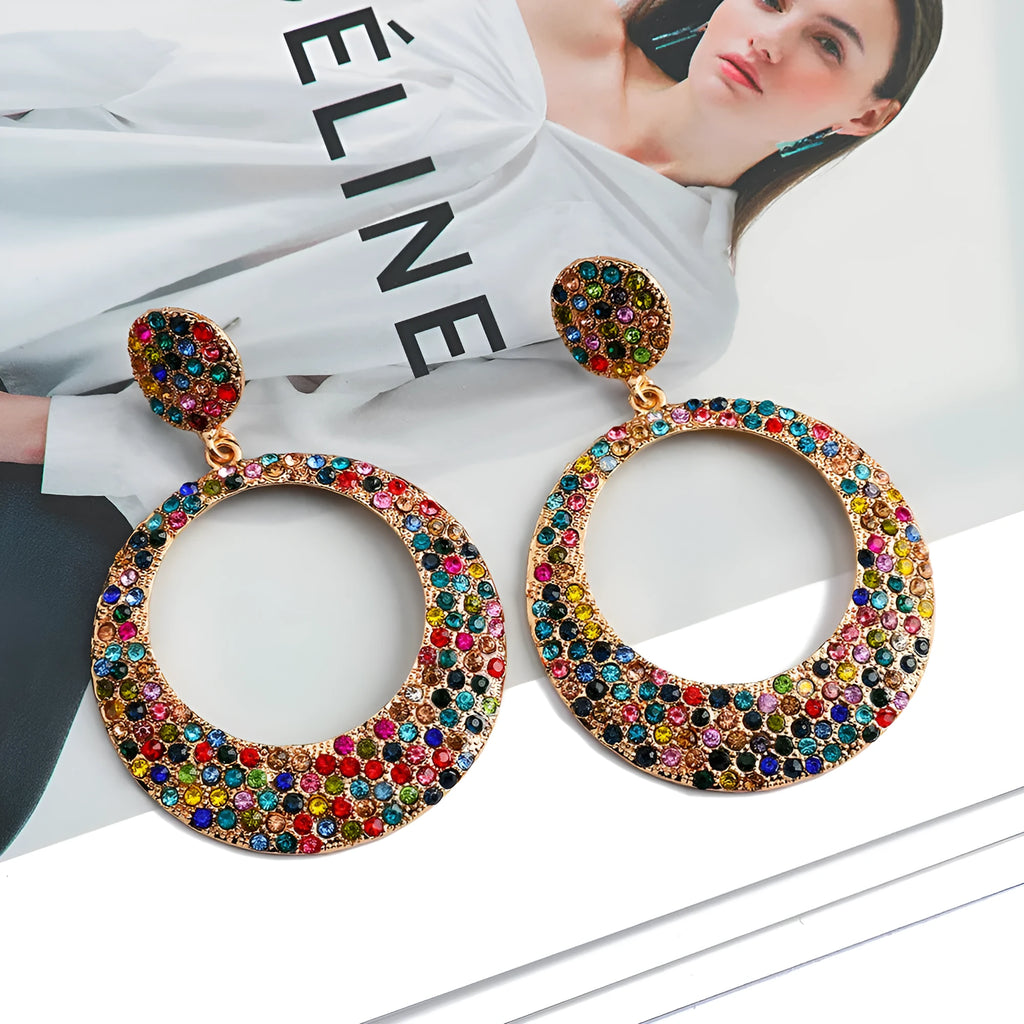 A pair of large round cartoon-style pendant earrings with coloured rhinestones on alloy metal.