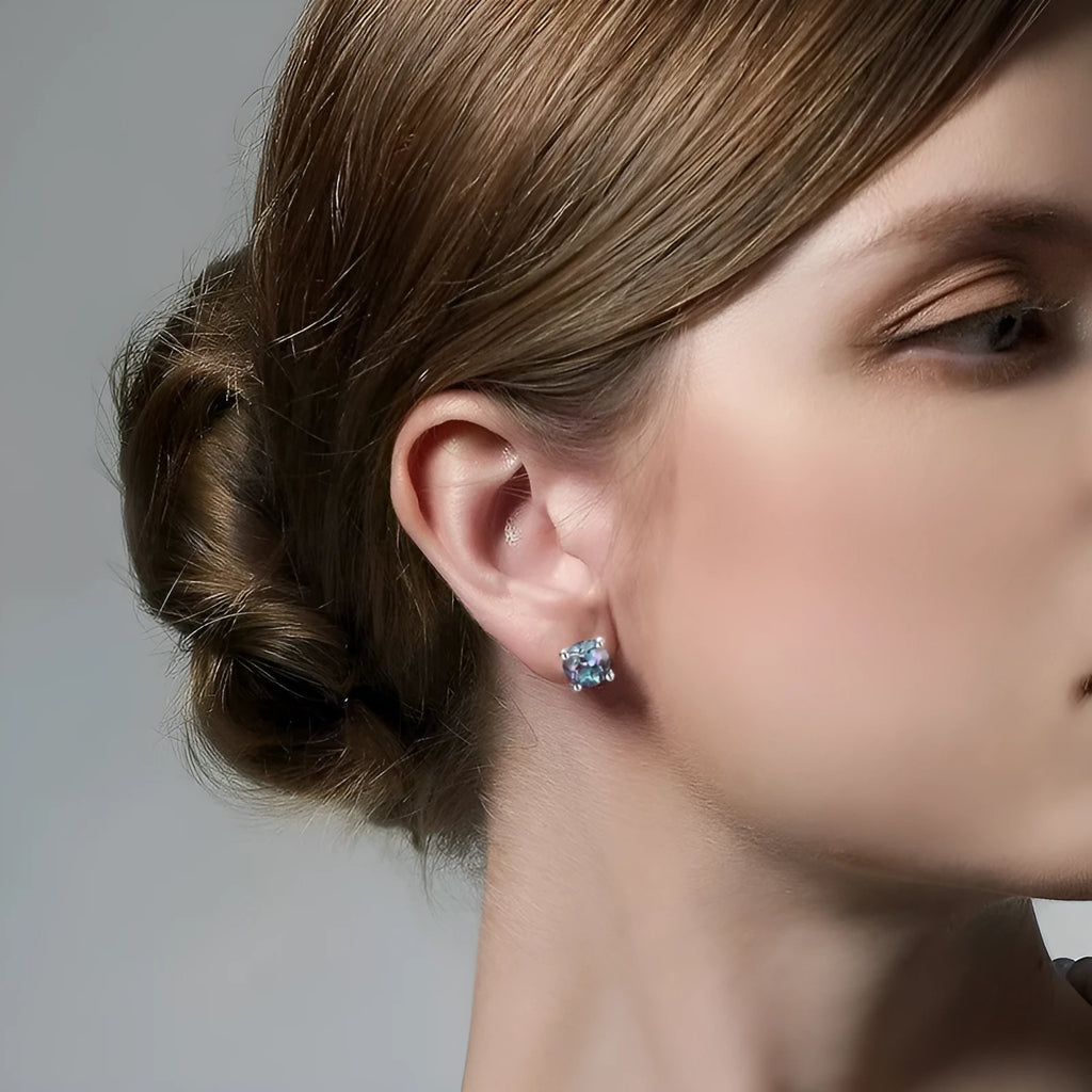 A pair of sterling silver geometric circle ear studs with a cultivated alexandrite stone.