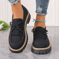 Black women's loafers with a tassel and bow knot on a chunky rubber sole.