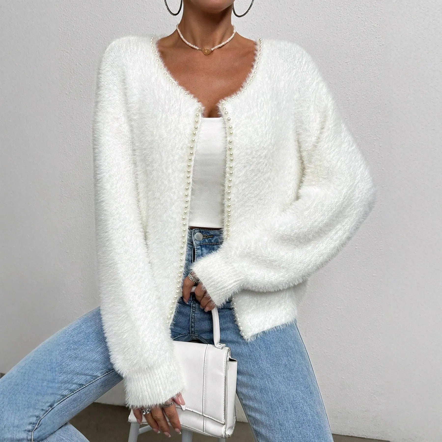 White women's V-neck cardigan sweater with bead-knit texture on a hanger.