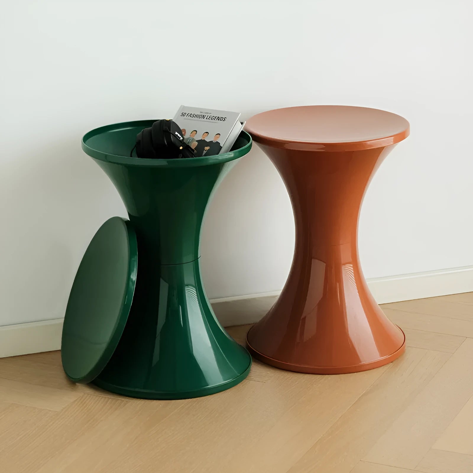 Green plastic hourglass-shaped shoe changing stool on a wooden floor.