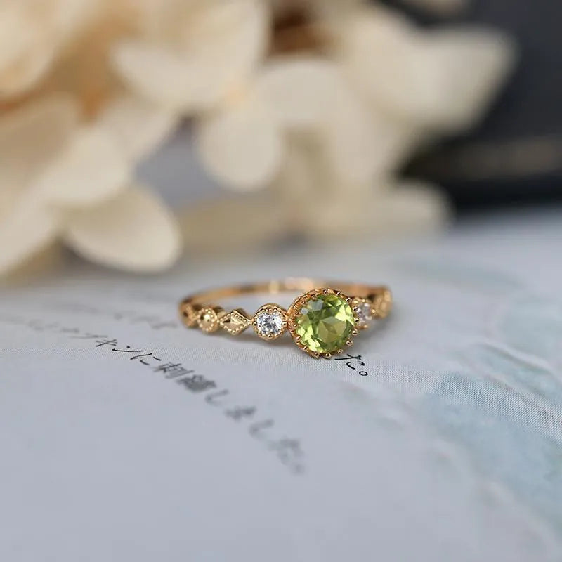 Japanese style geometric copper ring with green imitation peridot stone on a hand.
