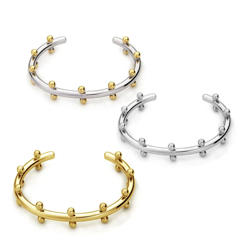 Close-up of stainless steel C-shaped textured bean beads in gold, steel, and steel-gold colours.