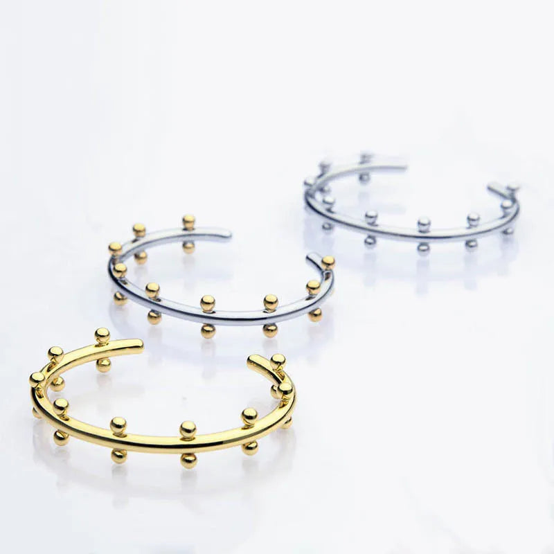 Close-up of stainless steel C-shaped textured bean beads in gold, steel, and steel-gold colours.